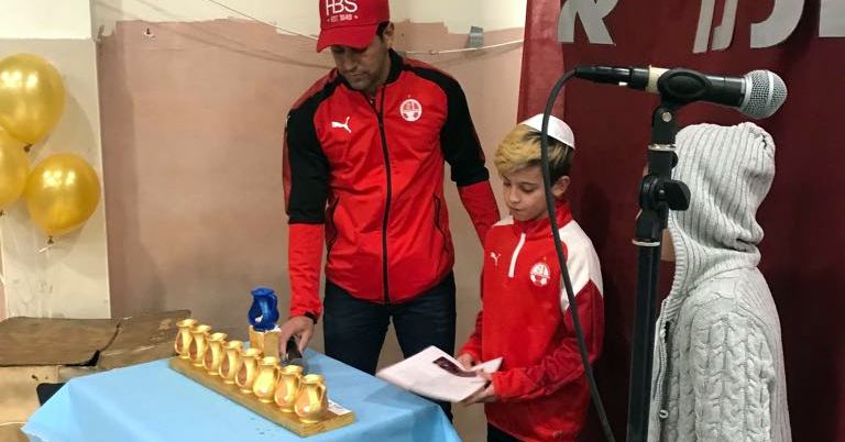 אליניב ברדה מדליק נר עם ילדי עמותת נגבה. צילום: עמותת נגבה