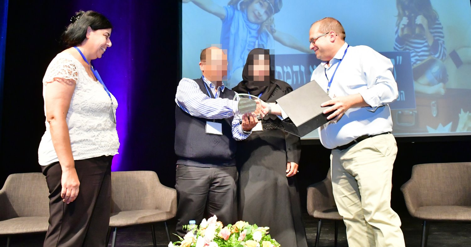 בני הזוג מקבלים אות הוקרה מבני סוויל בכנס החמישי של משפחתא, צילום באדיבות משפחתא קהילת האימוץ של ישראל