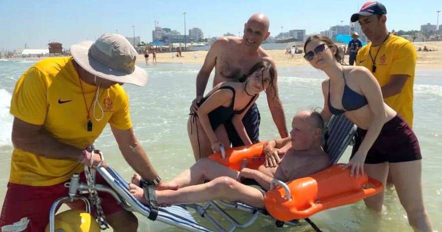 מיכאל קורץ עם בני משפחתו והמצילים בים באשדוד. צילום: שמואל דוד