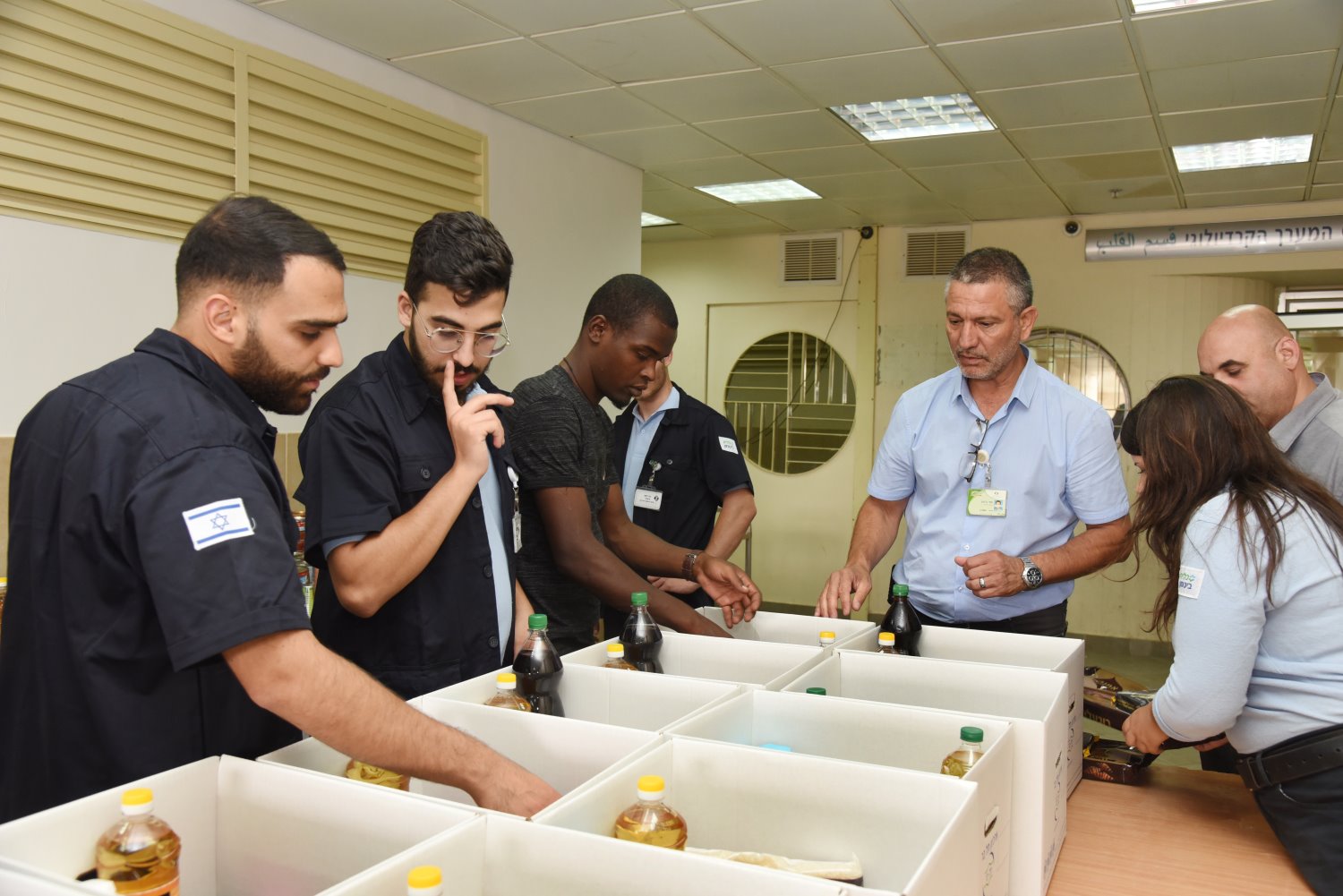 עמי ביטון, מנהל הביטחון בסורוקה וצוותו בהכנת חבילות התרומה למשפחות הנזקקות. צילום: דינה פרנקל