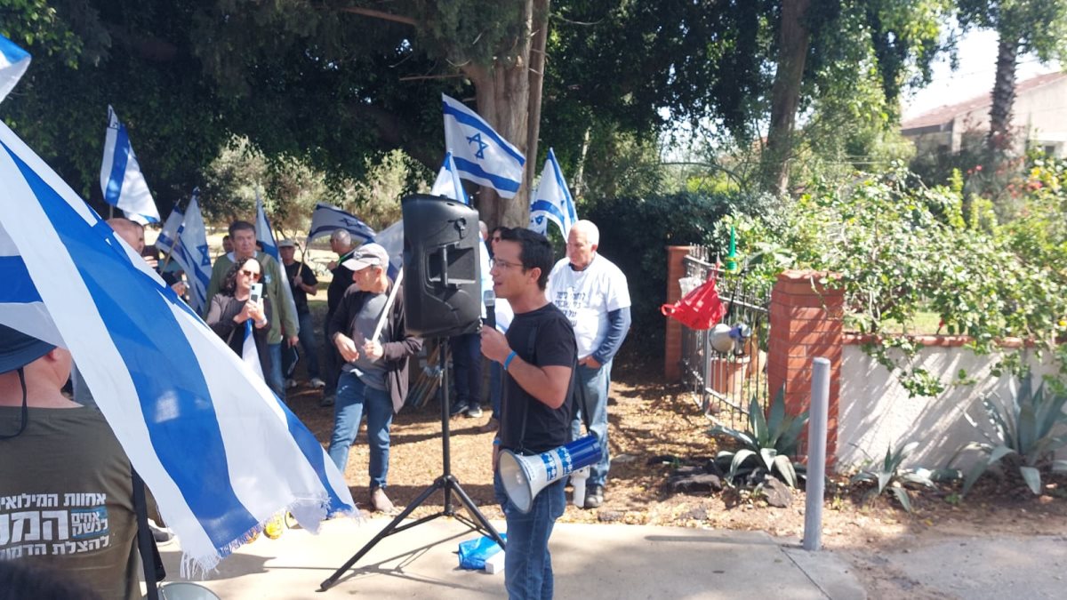 משה רדמן נואם מחוץ לביתו של השר דיכטר.