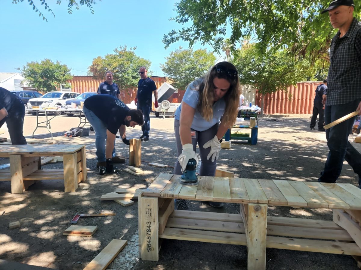עובדי נטפים בונים רהיטים ממשטחי עץ. צילום - יח''צ נטפים