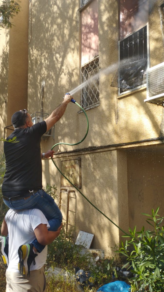 דדון, על כתפיו של אדם אחר, מכבה את השריפה. קרדיט - צילום פרטי