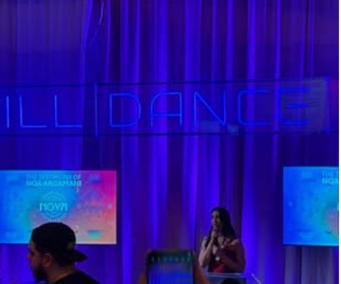 נועה ארגמני נושאת דברים במיצג הנובה במיאמי. תוכן גולשים שימוש לפי סעיף 27 א' בחוק זכויות