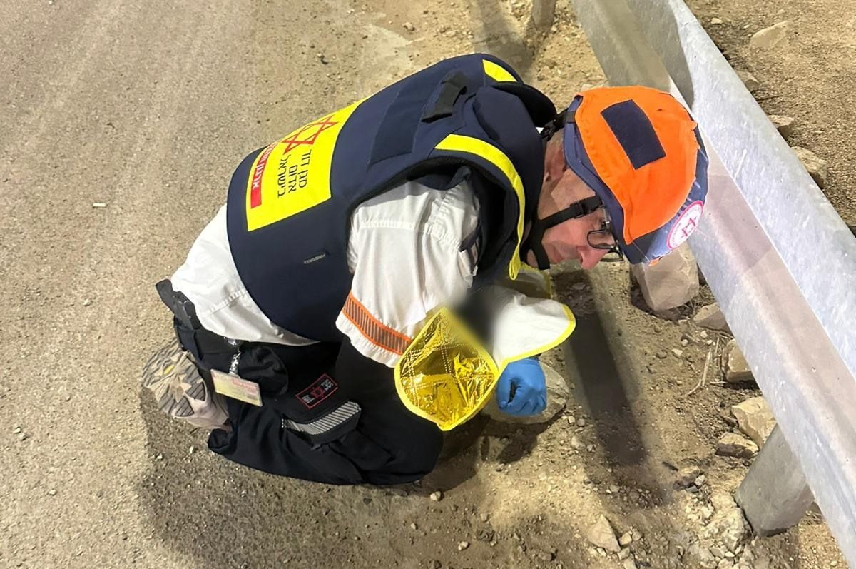 פראמדיק מד''א אלעד פס מגן בגופו על התינוק. קרדיט: מד''א