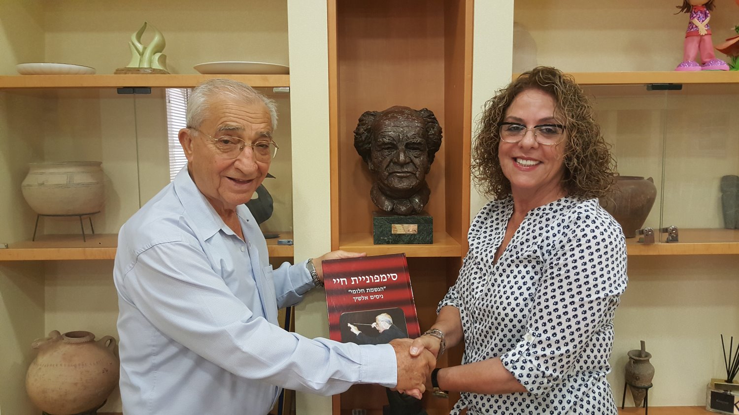 נסים אלשיך מעניק את ספרו לנשיאת האוניברסיטה, פרופ' רבקה כרמי. צילום: אוניברסיטת בן-גוריון