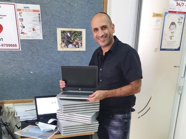 יוסי חן, רכז תקשוב הבית ספרי מכין למסירה את המחשבים שהתקבלו